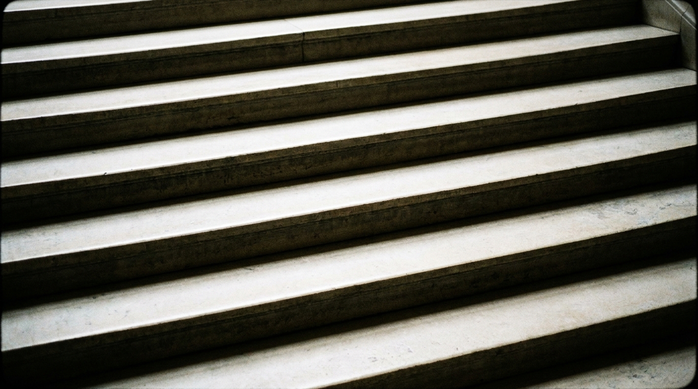Worn limestone stairs in an old exchange, shot from above so the treads read as parallel edges.